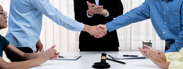 Lawyer acting as legal mediator successfully broke a compromise and seal with handshake between two parties to resolve business dispute through negotiation at law firm office. Panorama Rigid - obrazy, fototapety, plakaty