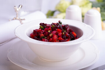 beet salad vinaigrette on a served dining table in a white deep plate