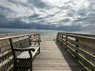 Fototapeta na wymiar A bench on a boardwalk leading to the beach on Fire Island, New York