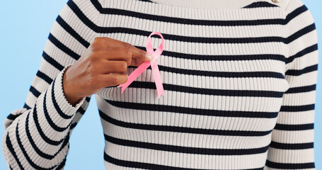 Hand, pink ribbon and breast cancer support with awareness and healthcare icon on blue background....