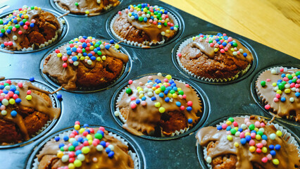 Delicious muffins with colorful sprinkles. Homemade cup cakes, sweet dessert, unhealthy food. Close...