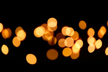 Fototapeta premium Wallpaper phone shining bokeh. Yellow bokeh on a black background. New Year and Christmas Festive background.Warm bokeh festive background.Shining texture 
