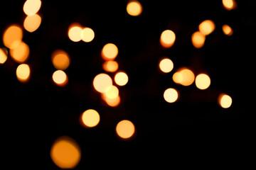 Wallpaper phone shining bokeh. Yellow bokeh on a black background. New Year and Christmas Festive background