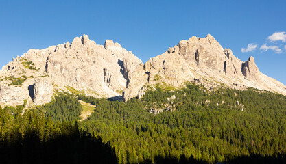 Amazing views of the picturesque high Dolomites mountains, lawns and summer forest