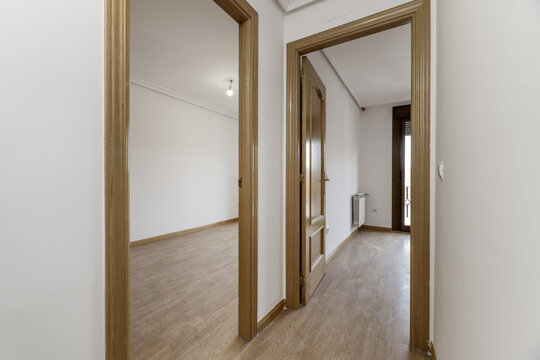 Hallway distributor of residence housing with oak wood carpentry on doors and moldings and light-colored flooring on the floor