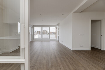 Fototapeta na wymiar Empty living room with large windows, synthetic wood flooring and access to terrace with glass and aluminum wall