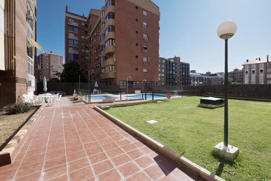 Gardens with grass in common areas of a residential housing complex with a communal pool