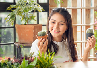 Portrait woman pretty young Asian girl beautiful wearing white blouse with long black hair and beautiful, smiling with bright smile and looking small tree In tree planting room Happily and relaxed