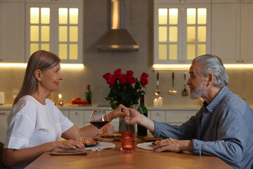 Affectionate senior couple having romantic dinner at home