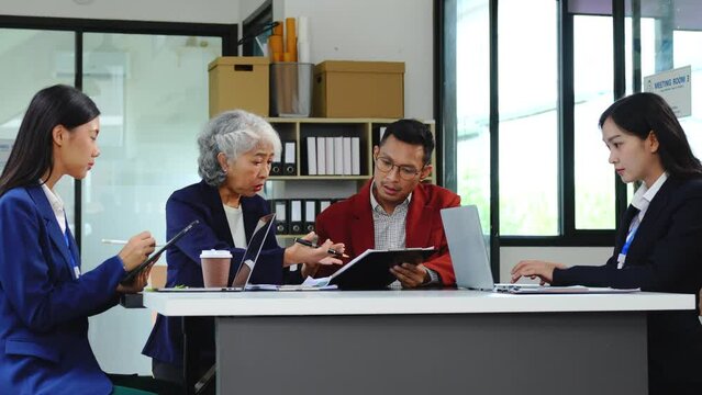 Four asian people in an office, working together on laptops, discussing tasks. annual gathering where attendees share and discuss opinions, presentation teamwork group meeting laptop in boardroom