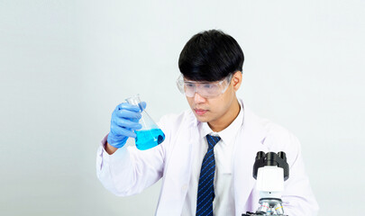 Portrait asian man student scientist Wearing a doctor gown in the lab looking hand at chemist....