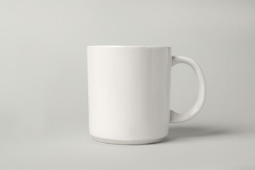 One white ceramic mug on light grey background