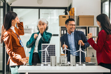 Four asian businesspeople professionals discuss renewable energy in office, showing solar panel and...