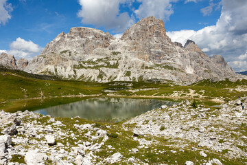 Sunny day in region Laghi dei piani. Meadow grasses on mountain slopes and high mountain peaks stretching into sky
