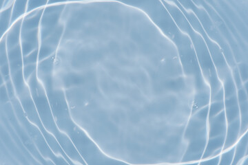 Defocus blurred transparent blue colored clear calm water surface texture with splashes reflection. Trendy abstract nature background. Water waves in sunlight with copy space. Blue watercolor shine.