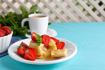 Tasty vanilla fondant with white chocolate and strawberries on light blue wooden table, space for...