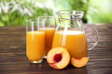 Tasty peach juice and fresh fruit on wooden table outdoors