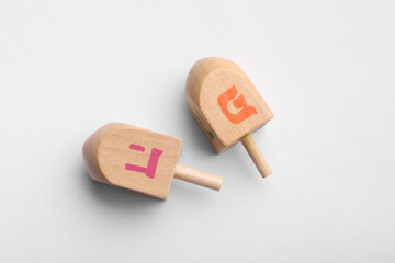 Wooden dreidels on white background, flat lay. Traditional Hanukkah game