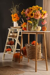 Room decorated with pumpkins and bright flowers. Autumn vibes