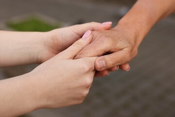 Trust and support. Women joining hands outdoors, closeup