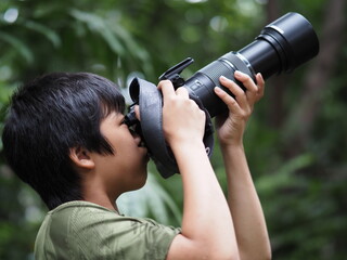 Boy using digital camera taking photo in the nature, hobbies concept
