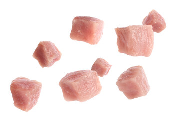 Pieces of raw pork for goulash flying on white background