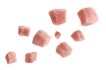 Pieces of raw pork for goulash flying on white background