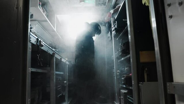 Male standing in smoky armory preparing, putting together his loadout.