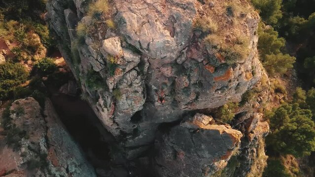 Aerial view of woman rapel down a mountain climbing a big rock