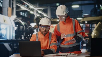 Team factory workers talking together looking laptop computer at production. - Powered by Adobe
