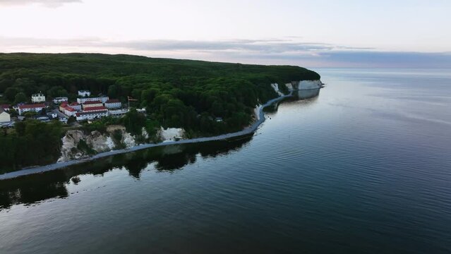 Aerial view passing the Sassnitz city, toward the steep coast of Jasmund National Park, dusk in Rugen, Germany