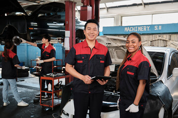 Portrait of professional mechanic supervisor partners look at camera, work at car service garage, happy maintenance jobs, check and repair engineer occupation in automotive industry business.