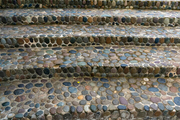 Steps made of flat rounded multi-colored stones. The stones were brought from the sea coast, laid side by side and filled with cement mortar.