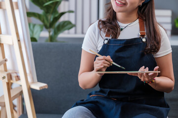 Portrait of a young asian student sitting with still life painting at the studio