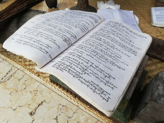 Old book with traditional Balinese written on alphabet, placed on the table