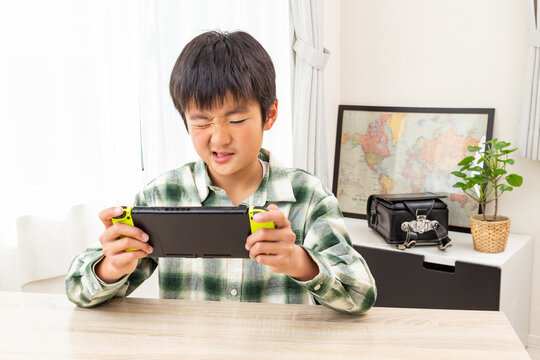子供部屋でゲームをする男の子