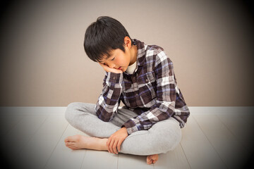 Fototapeta premium 部屋で落ち込む男の子
