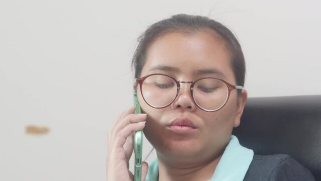 Closeup of Asian woman's face talking with co-workers at work