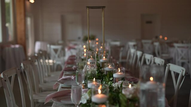 beautifully arranged long table setup for a wedding reception, adorned with delicate candles, fresh flowers, and all the details that contribute to a romantic and stylish ambiance.