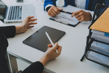 Entrepreneur Asian businessman and businesswoman discussing new business project in tablet in modern Meeting In Modern Office, Asian business casual concept.