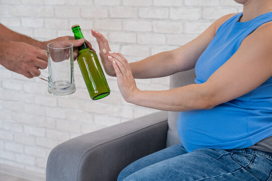 A pregnant woman refuses beer.