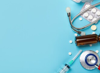 Pills and medical equiupments including stethoscope, syringe at border on light blue background, panoramic banner top view with copy space. Ai generated.