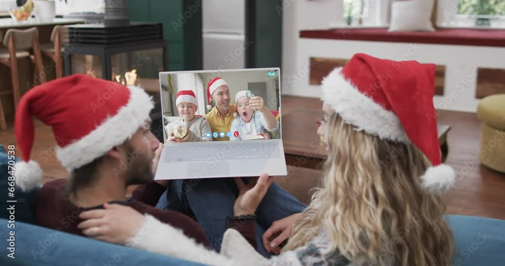 Wall mural Happy caucasian couple and father with sons having christmas laptop video call, slow motion