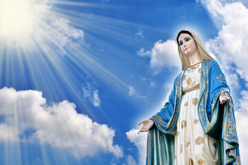 Closeup of Statue of Our lady of grace virgin Mary view with blurred bright blue background in the...