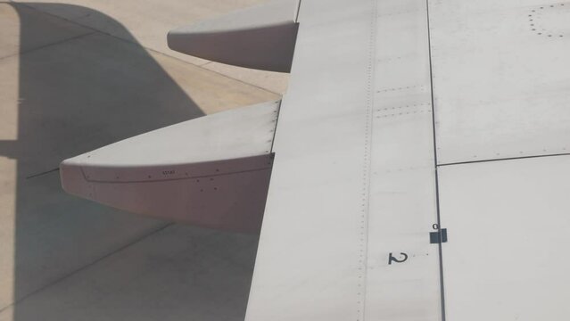 view through airplane window to the wing while aircraft push back from gate ready to travel