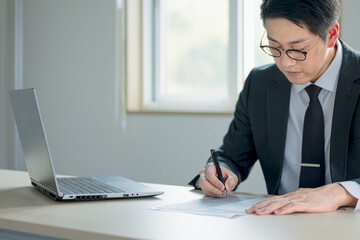 書類を書き込むビジネスマン