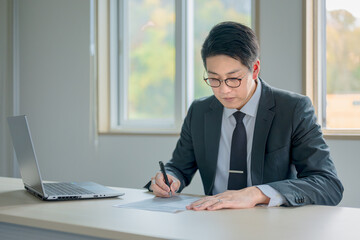 書類を書き込むビジネスマン
