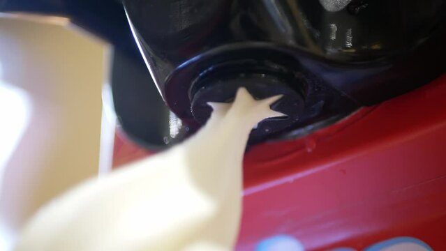 close up view to ice cream maker machine in soft serve style while make a cone of fresh milk ice cream