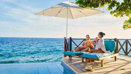Curacao, couple man and woman mid age relaxing by the swimming pool during vacation in the Caribbean - Powered by Adobe