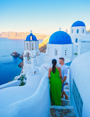 Couple on vacation in Santorini Greece, men and women at the Greek village of Oia - obrazy, fototapety, plakaty